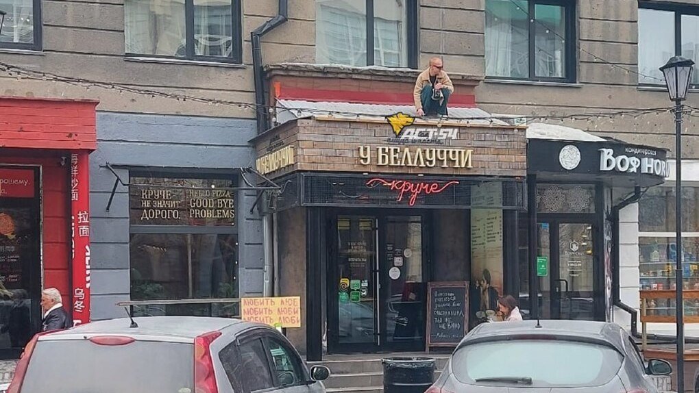 В центре Новосибирска заметили мужчину на крыше кафе с бутылкой шампанского и в чёрных очках