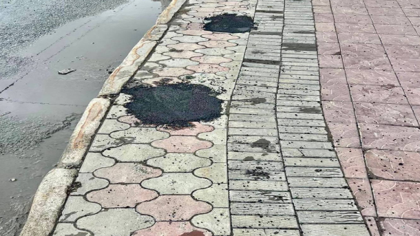 На площади Калинина в Новосибирске дорожники заделывают дыры в плитке асфальтом