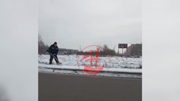 Рабочие «стригли» снег с газонокосилками в руках вдоль обочины в Новосибирске