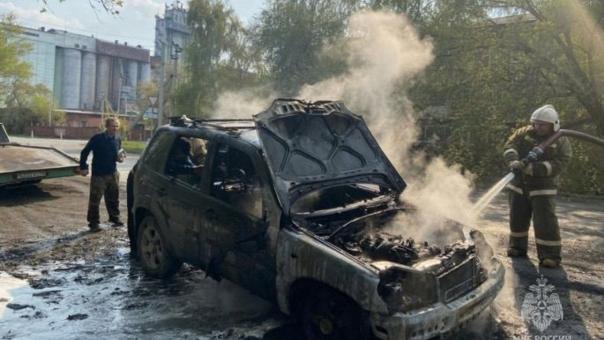 У омича посреди дня загорелась машина во дворе дома