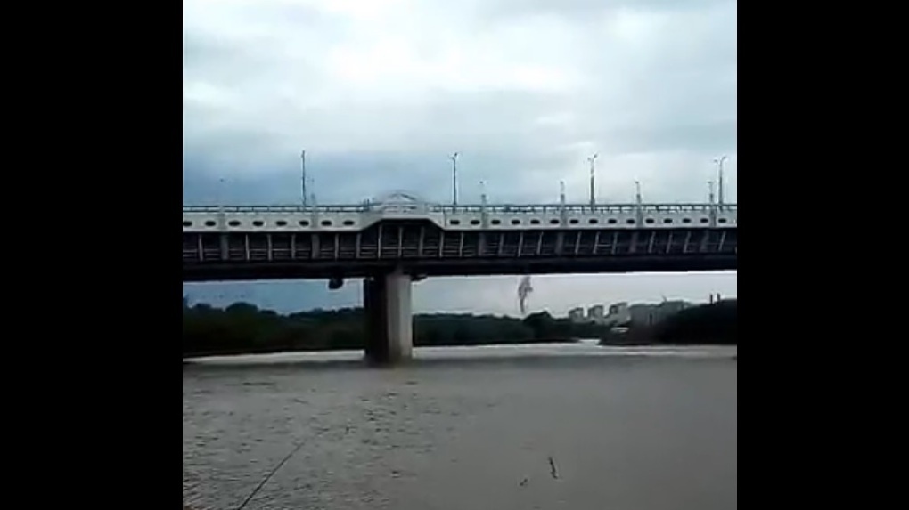 Омские рабочие скидывали пыль с моста в реку