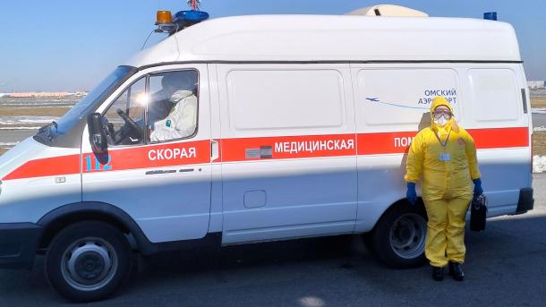 Омичам объяснили, откуда в аэропорту люди в костюмах химзащиты