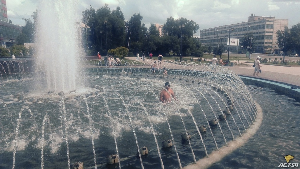 Новосибирцы спасаются от жары в фонтане