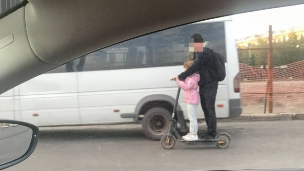Ехали рядом с машинами: новосибирец прокатился с ребёнком на электросамокате по оживлённой улице