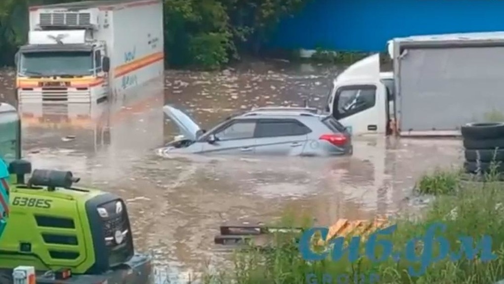 Автомобили ушли под воду: стоянку затопило после ливня в Новосибирске. ВИДЕО