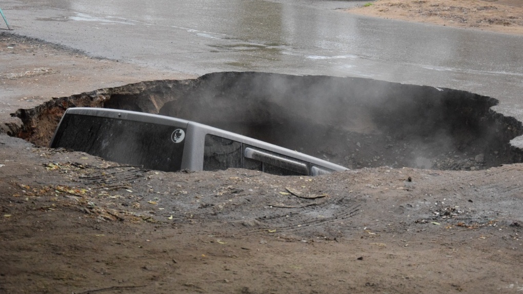 Утонувшую в яме с кипятком машину в центре Омска не могут извлечь (подробности)