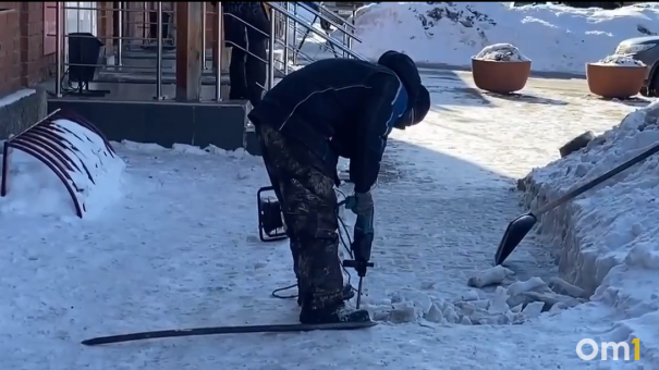 Новосибирец убирает снег с тротуаров перфоратором