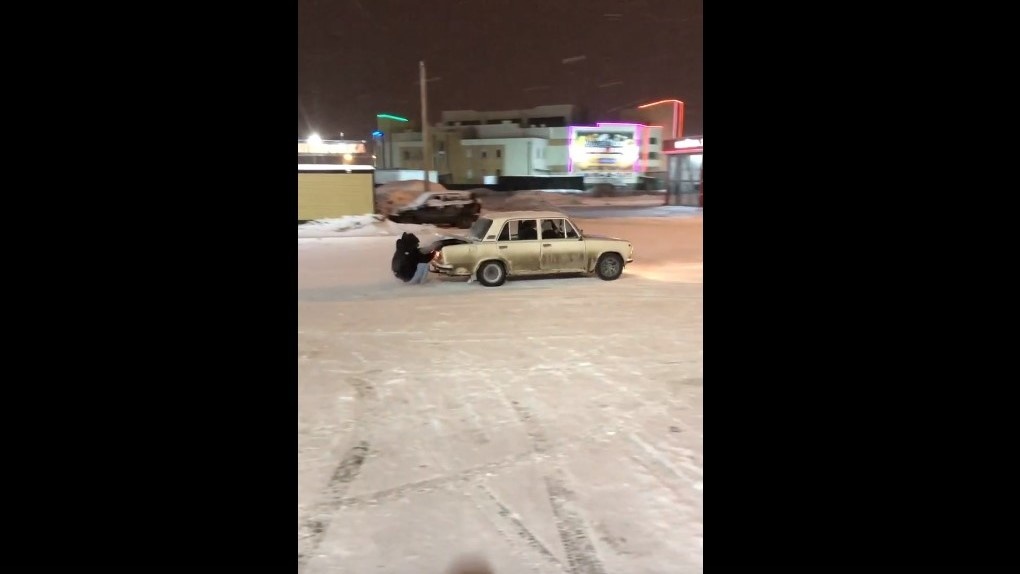 В Омске двое парней устроили дрифт на парковке, зацепившись за багажник